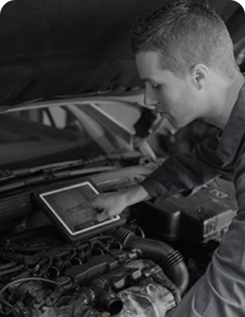 Automotive technician using tablet for smart car diagnostics and engine analysis under the hood