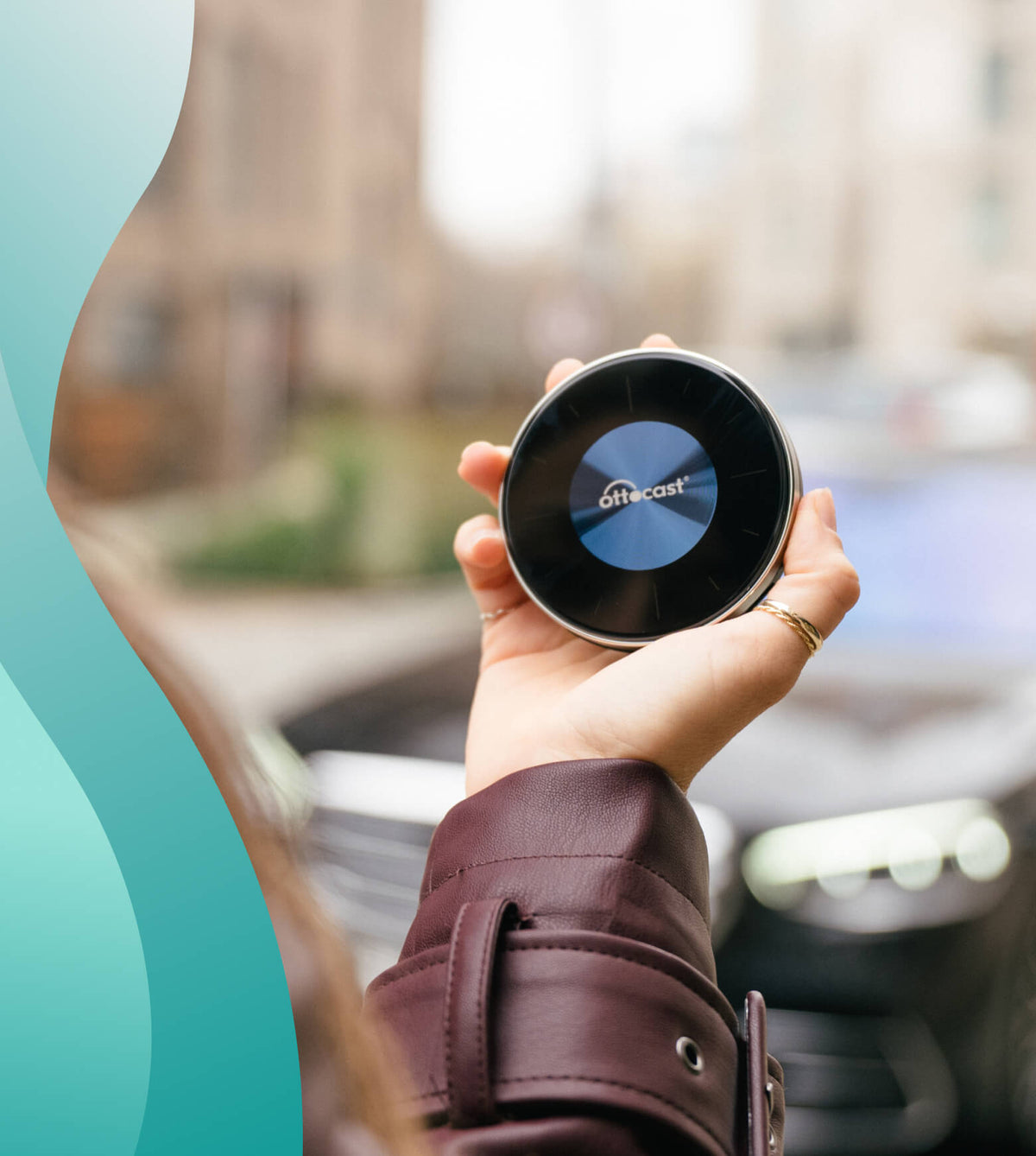 Hand holding Ottocast OttoAibox P3 wireless CarPlay AI Box device outdoors in front of car