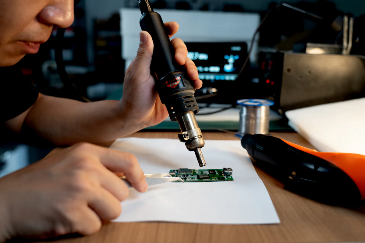 Engineer soldering electronic circuit board for precision technology and seamless device performance